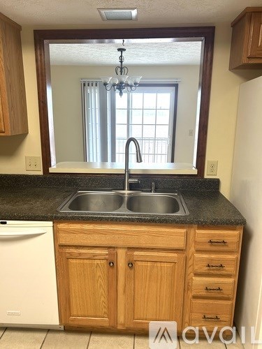 A kitchen with wooden cabinets and a black countertop.