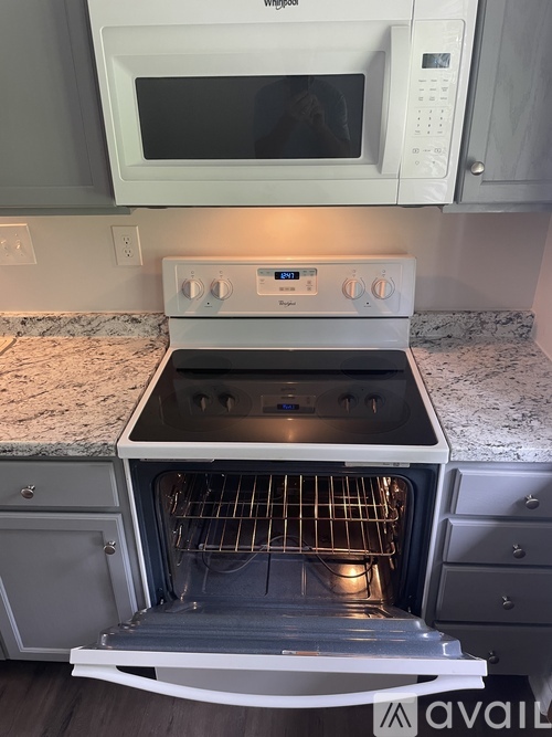 A white oven with a stove top and microwave above it.