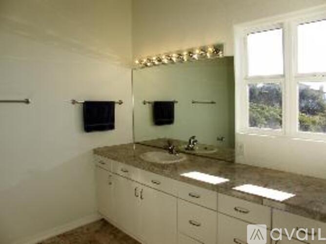 A bathroom with a vanity and a large mirror.