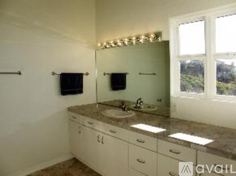 A bathroom with a vanity and a large mirror.