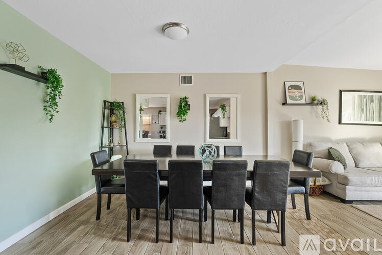 A dining room with a table set for six and a couch in the corner.