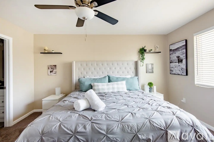 A bedroom with a large bed and a ceiling fan.