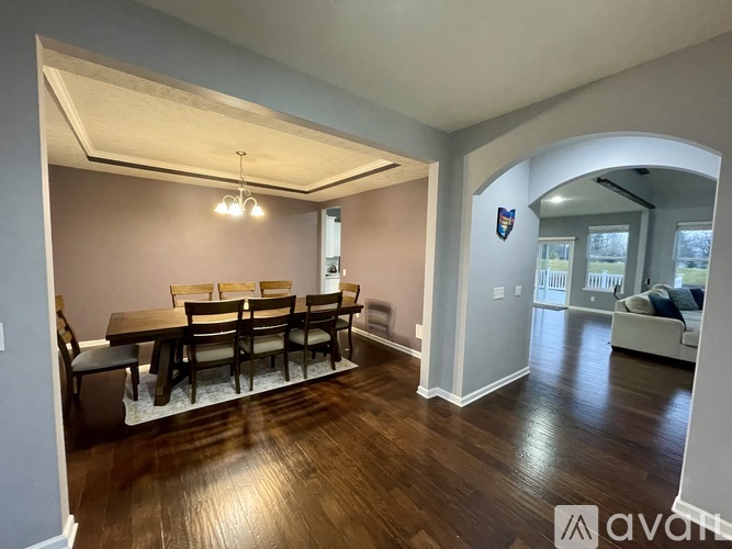A dining room with a wooden table and chairs.