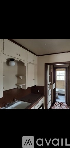 A kitchen with white cabinets and a window.