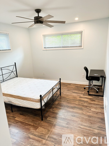 A bedroom with a bed, desk, and chair.