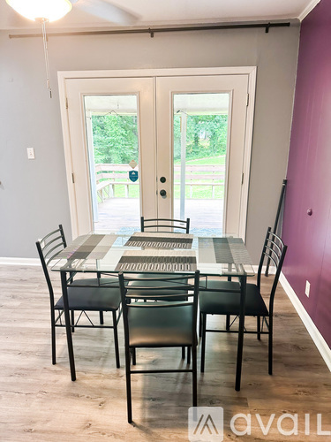 A dining room with a table and chairs.