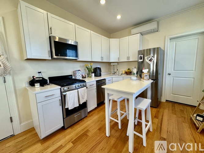 A kitchen with white cabinets and a wooden floor.