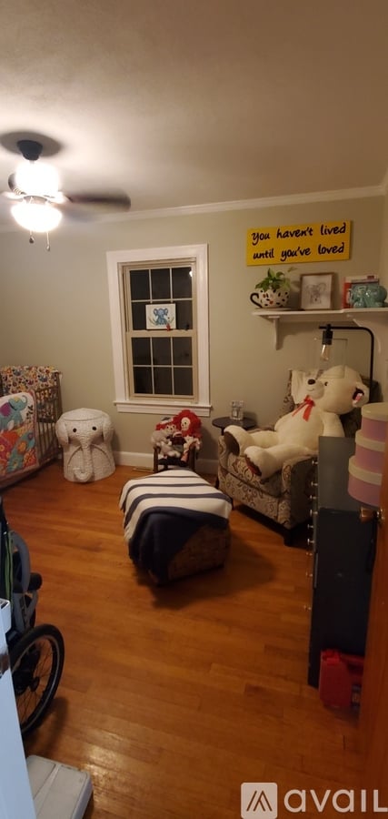 A room with a window and a shelf with stuffed animals on it.