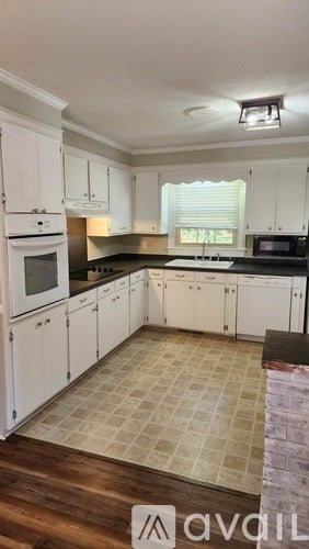A kitchen with white cabinets and a tile floor.