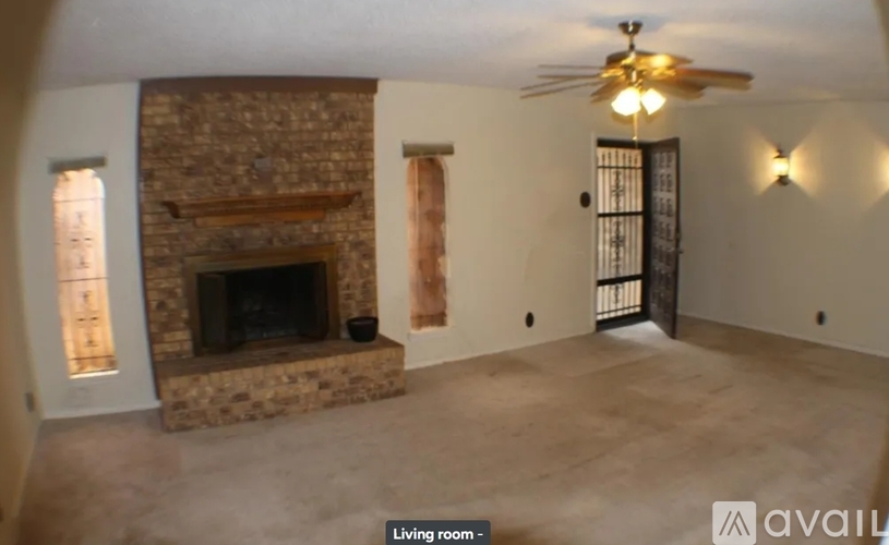 A living room with a fireplace and a ceiling fan.