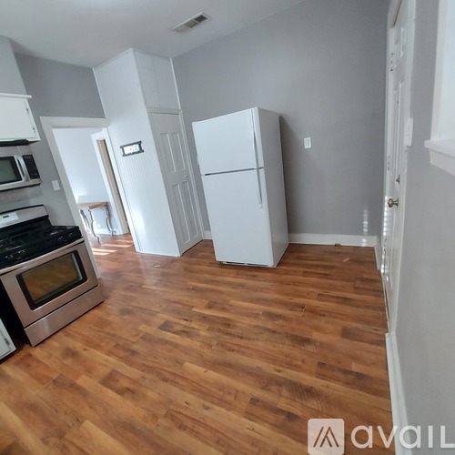 A kitchen with a stove top oven and a refrigerator.