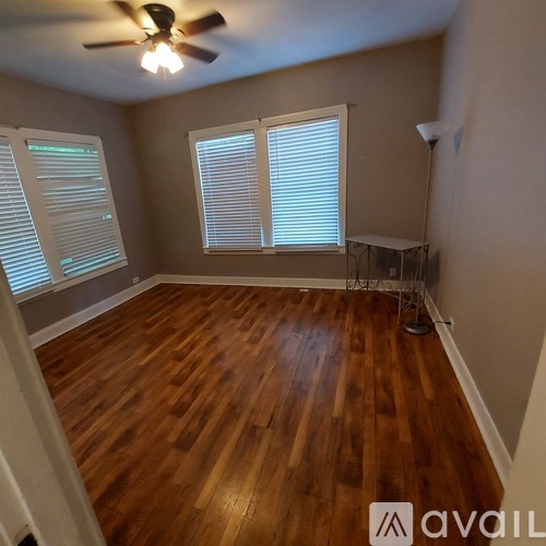 A room with wooden floors and a ceiling fan.