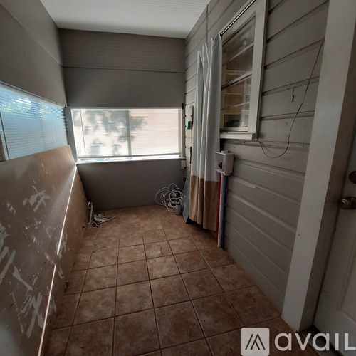 A room with a window and a tiled floor.