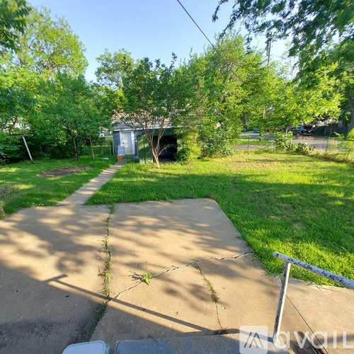 A backyard with a concrete walkway and a shed.
