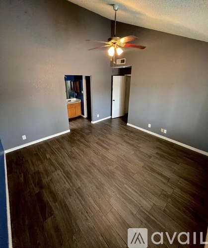 A room with wooden flooring and a ceiling fan.