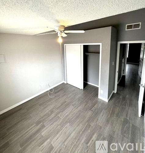 A room with a ceiling fan and a grey floor.