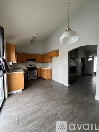 A kitchen with wooden cabinets and a grey floor.