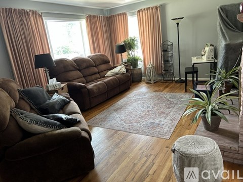 A living room with brown furniture and a rug.