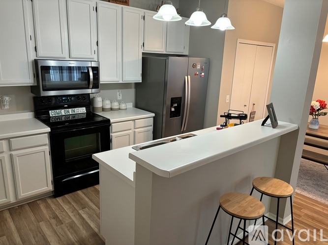A kitchen with white cabinets and a black oven with a digital display on the front.