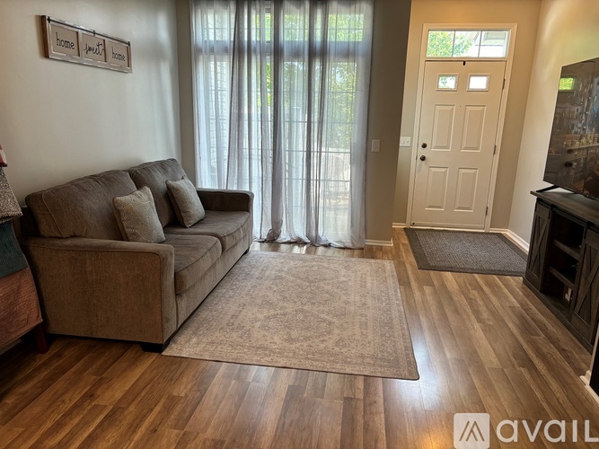 A living room with a couch, a rug, and a door.