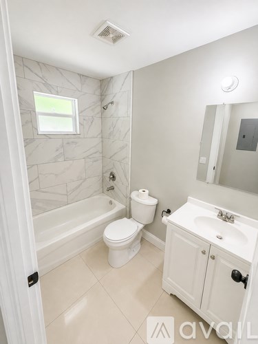 A white bathroom with a toilet, sink, and tub.
