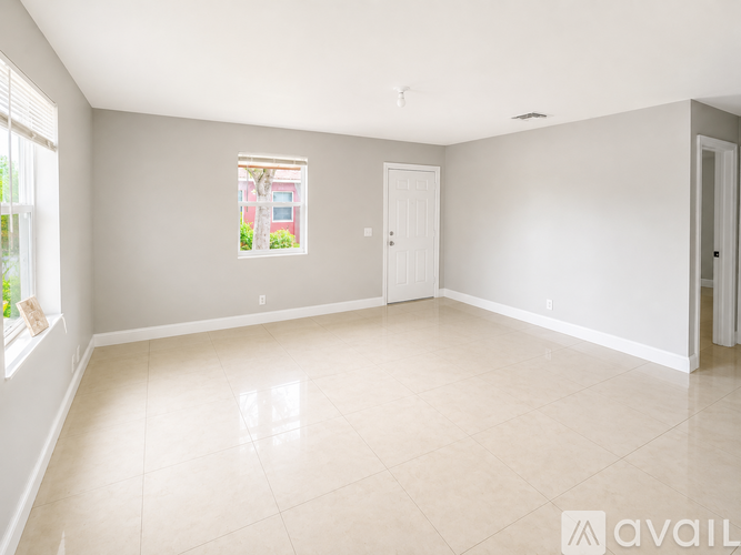 A spacious room with a large window and a view of a building outside.