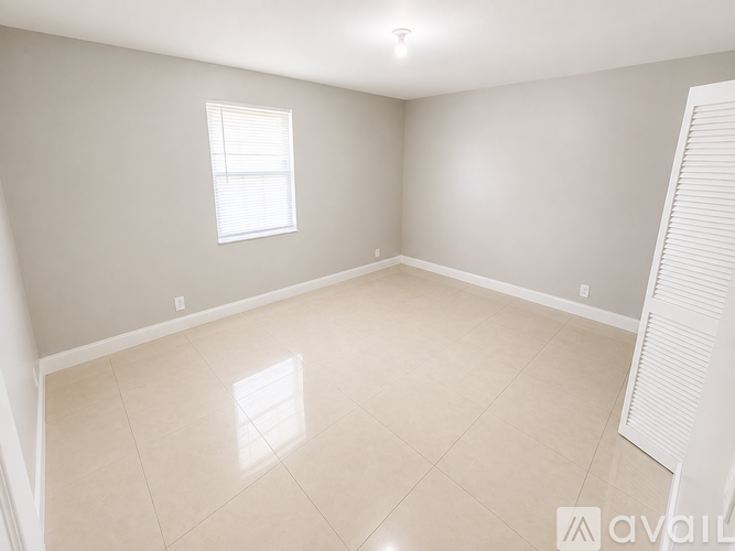 A room with a window and a tiled floor.
