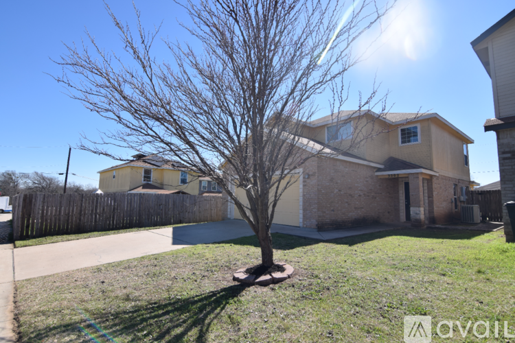 A house with a bare tree in front of it.