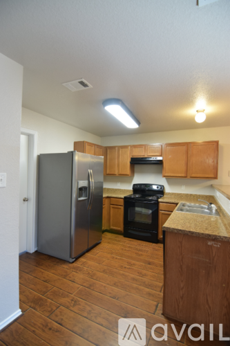 A kitchen with wooden cabinets and a stainless steel refrigerator.