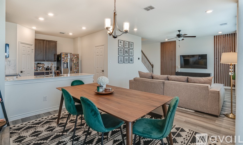 A dining room with a wooden table and green chairs.