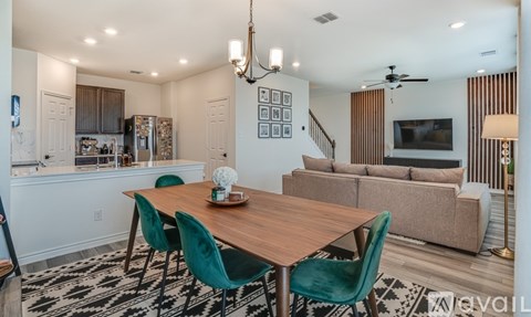 A dining room with a wooden table and green chairs.