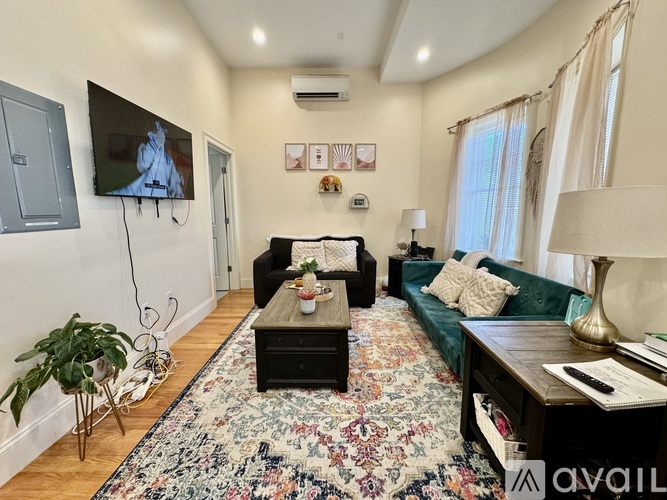 A living room with a couch, a coffee table, and a television.