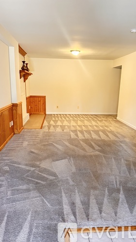 A room with a carpet and a wooden cabinet.
