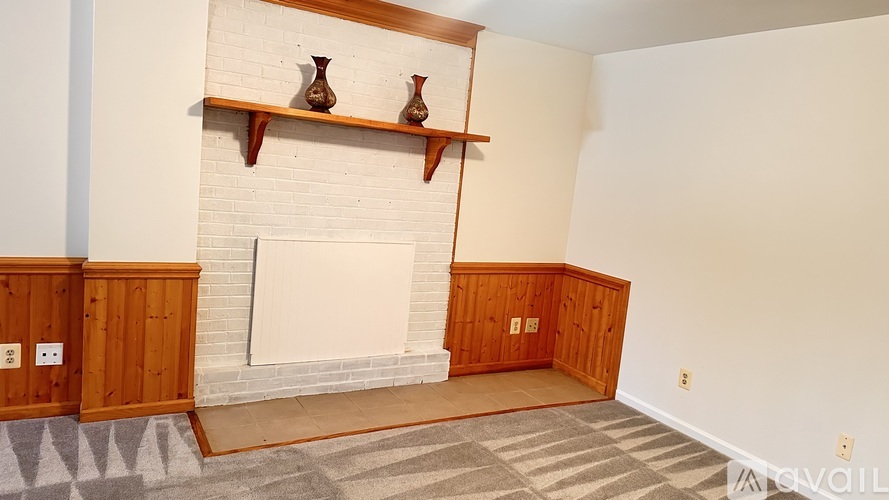 A living room with a fireplace and two vases on top of it.