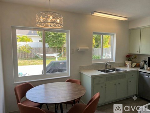 A kitchen with a table and chairs and a window.