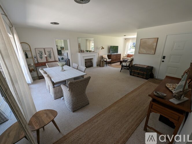 A living room with a fireplace and a dining table.