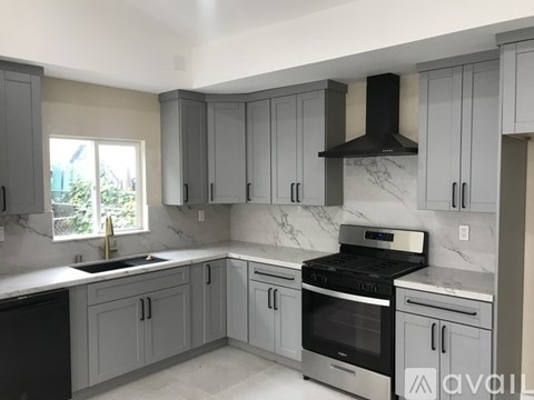 A kitchen with a black stove top oven and a black dishwasher.