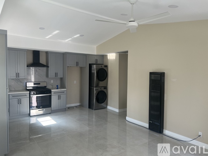 A spacious kitchen with a marble countertop and stainless steel appliances.