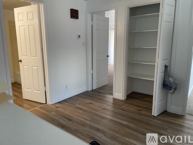 A room with white doors and a wooden floor.