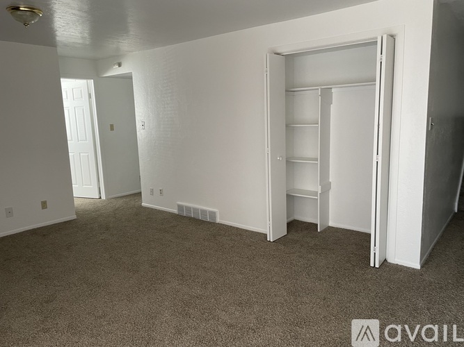 A room with a carpeted floor and a white door.