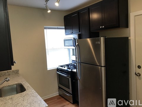 A kitchen with a stainless steel refrigerator, oven, and sink.