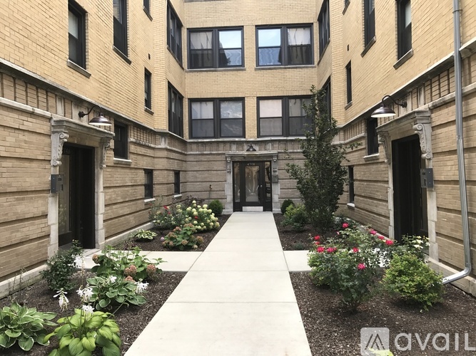 A courtyard with a walkway and plants on either side.