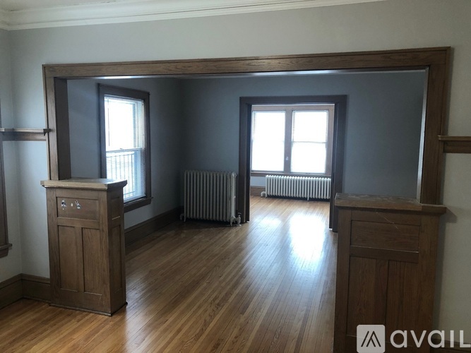 A room with wooden floors and furniture, including a wooden cabinet and a wooden dresser.