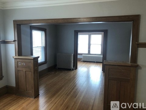 A room with wooden floors and furniture, including a wooden cabinet and a wooden dresser.