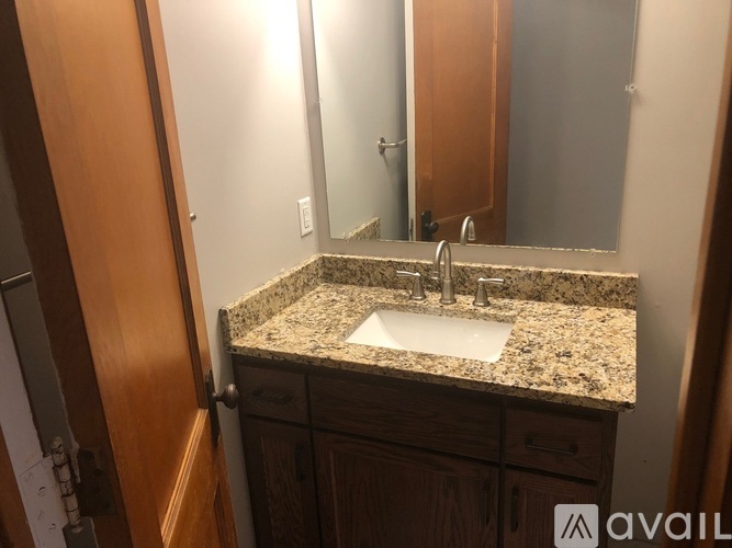 A bathroom with a granite countertop and a sink.
