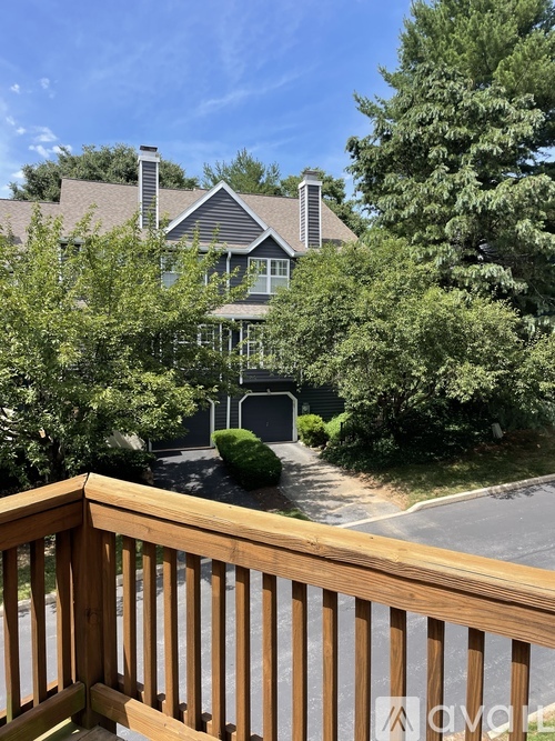 A house with a brown roof and a wooden deck in front.