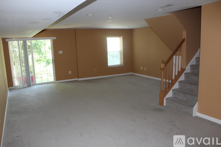 A spacious room with a staircase and a window.
