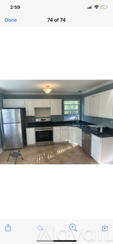 A kitchen with white cabinets and a black countertop.