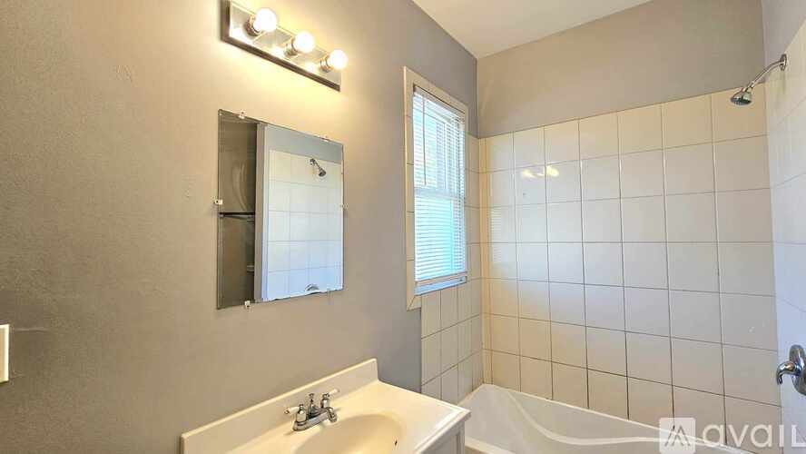 A bathroom with a white sink and a mirror above it.
