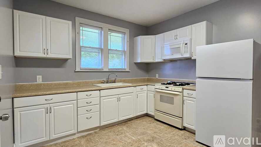 A kitchen with white appliances and cabinets.
